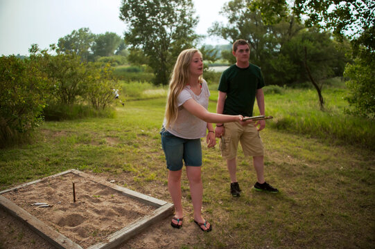 Brother and sister play horseshoes at an annual July 4th yard party; Bennet, Nebraska, United States of America