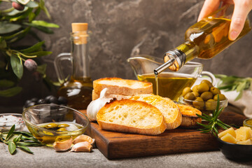 Italian ciabatta bread with olives, garlic, parmesan and rosemary on a dark marble background....