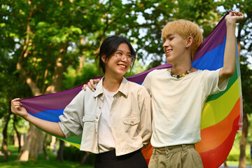 Portrait with LGBT adolescent boy and girl holding pride flag together, Celebration Pride month concept.