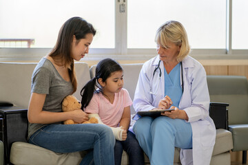 Fototapeta premium Pediatrician is closely caring and asking about sick girls symptoms, health concepts and child care.