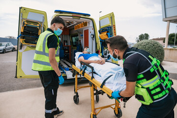 Emergency medical technicians taking patient away in automobile