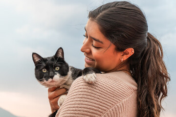 Woman embracing adorable stray cat