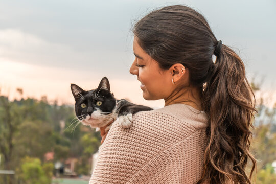 Woman embracing adorable stray cat