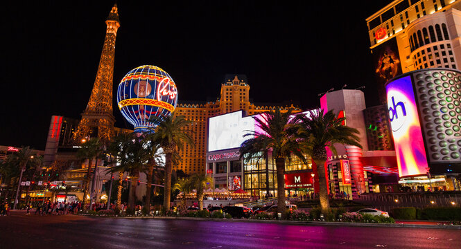 Las Vegas Boulevard aka The Strip at night lit by neon signs and large screens with ads