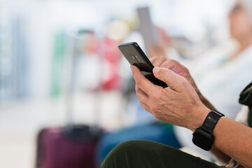 Crop woman with smartphone in waiting room