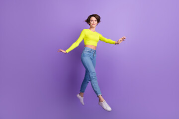 Fototapeta na wymiar Full length photo of active carefree lovely person jumping running have good mood isolated on violet color background