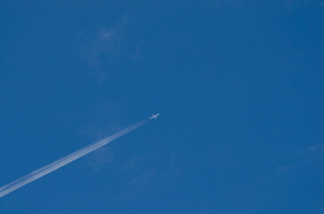 Airplane in flight with smoke trail and blue background