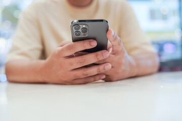 Relaxed young asian man using smart phone  spending time checking news social media.