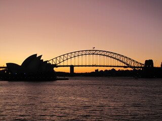 Silhouette of the Harbour Bridge and the Opera House against an evening sky in Sydney, Australia