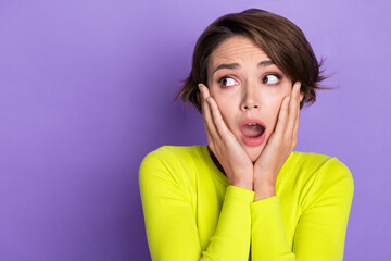 Photo of funny young girl hands cheeks frightened confused watching empty space zombies walking streets isolated on purple color background