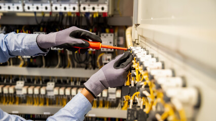 Electricians work to connect electric wires in the system, switchboard, electrical system in...