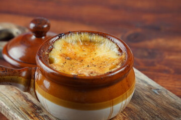 Braised beef with oven baked potatoes under cheese crust in clay bowl. Rustic style