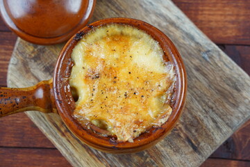 Braised beef with oven baked potatoes under cheese crust in clay bowl. Rustic style