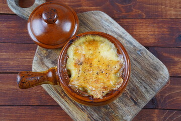 Braised beef with oven baked potatoes under cheese crust in clay bowl. Rustic style