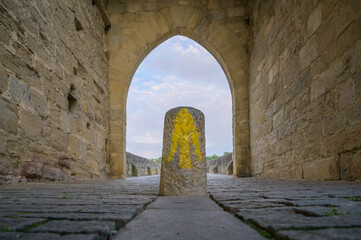 Fototapeta na wymiar Way marking with yellow arrow symbol sign on St. James Pilgrimage route in Puente la Reina, Navarra