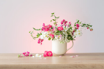 summer flowers in ceramic cup on light background