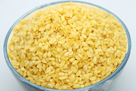 Moong Dal Namkeeen, Indian Namkeen Snack Food, Moong dal isolated served in a blue bowl in top view, white background. Mixture, Yellow split salty mung dal or moong dal namkeen. Top close up.