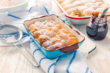 Sweet rolls, Buchteln (buchty) filled with plum jam or jelly with backing ingredients