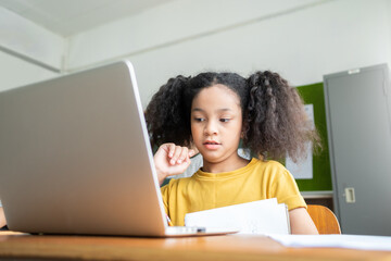 African American Elementary schoolgirl studying with laptop, E-Learning 
