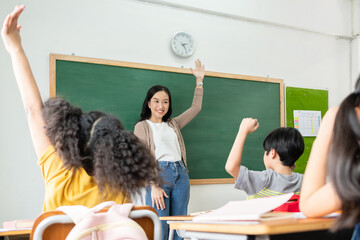 Asian Students raising hands up Answer Question at elementary school