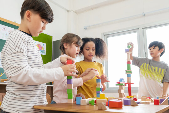 Diversity Elementary School kids playing wooden toy blocks in Classroom