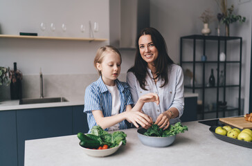 Happy mother and daughter cooking together in kitchen
