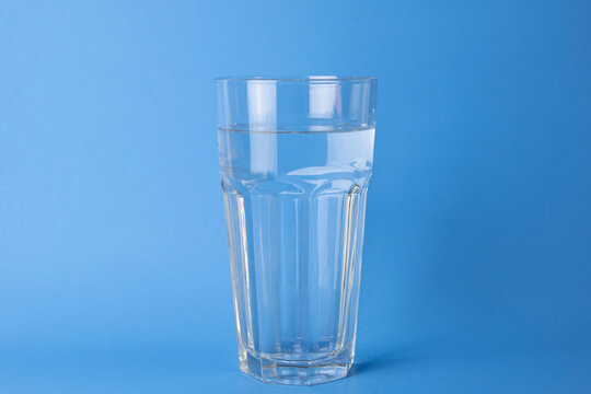 The clear glass of pure water on the blue background