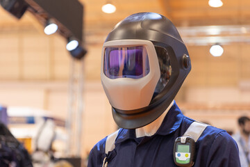 A man trying on protective helmet for welding at the expo