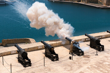 Traditional firing of the cannon saluting battery at noon in Valletta, Malta.