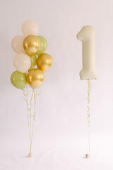 Multicolored balloons for a child's first birthday on a white background