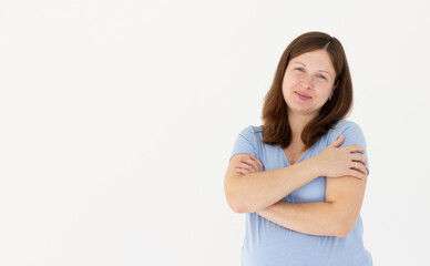Fototapeta premium Photo of overjoyed pregnant lady good mood hands hug herself shoulders enjoy joyful smile wear blue t-shirt isolated white color background