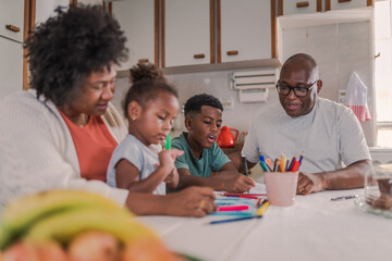 Latin parents at the kitchen table helping their children with their homework in Brazil