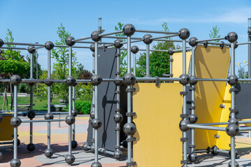 Outdoor sports ground in the city park. Street exercise equipment with horizontal bars, columns and balances. Street gym for all active people. Concept of fitness and healthy lifestyle. Details metal.