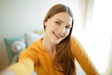 Young woman taking selfie while having fun at home, portrait