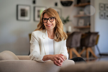 Portrait of an attractive middle aged woman relaxing in an armchair in a modern home