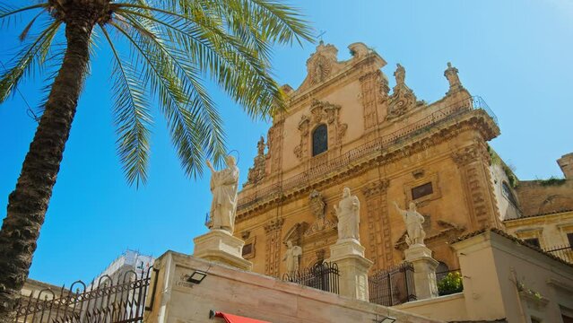 Highly decorated facade of the Church of Saint Peter in Modica. Baroque-style cathedral with beautiful overlapping of stairs, statues, and baroque details.