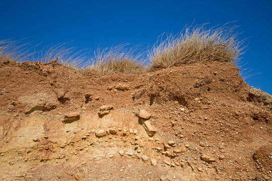 Stony soil profile under grassland on the Greek island Crete under a blue sky