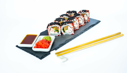 Sushi rolls on a black slate plate with soy sauce, ginger and wasabi. Japanese food, eating healthy