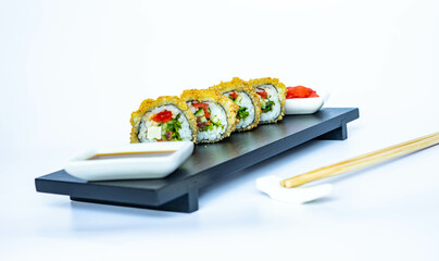 Vegan tempura rolls with tofu and vegetables, on a black bamboo plate, on a white background. Japanese food, eating healthy