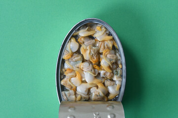 close up of can of cockles on green background