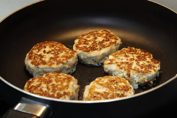 Frying pan with salmon cutlets, close-up