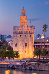 The golden tower of Torre del Oro in night illumination at sunset.