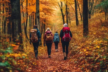 Fototapete Schokoladenbraun Couple with backpacks walking on path in autumn season forest