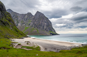 Fototapeta na wymiar Sandy beach surrounded by mountains on the sea coast - Kvalvika Beach, Lofoten, Norway