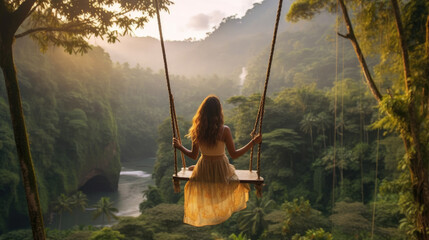 Beautiful girl enjoying freedom on swing in Bali, Indonesia - obrazy, fototapety, plakaty