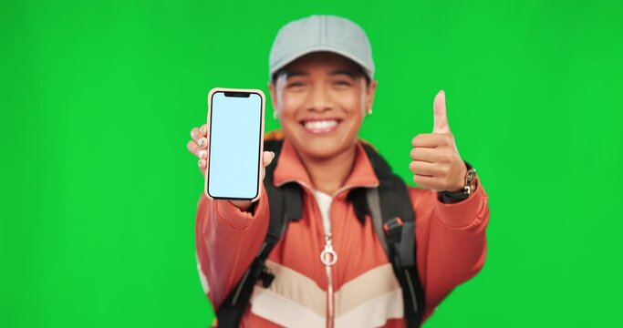 Hiking, woman and thumbs up with phone on green screen for website review or social media. Young female model person with a backpack and smartphone on studio background advertising travel app mockup