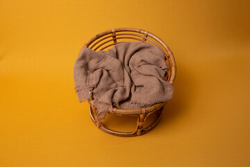 wicker chair on a yellow background. bed for a photo session of a newborn. small bed. bed for dolls