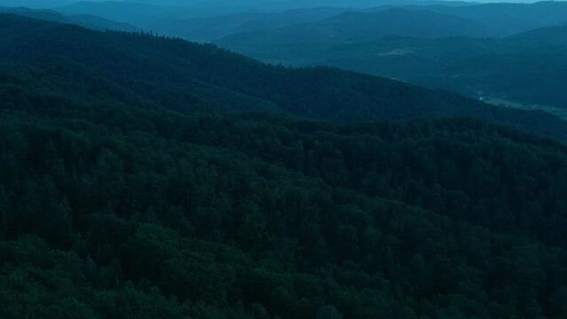 Great mountain range with colorful clouds from bird's eye view. Cinematic drone shot amazing evening Carpathian mountains. Aerial footage various forests at night time. Beauty of earth