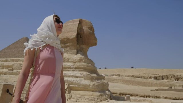 Young woman standing in front of the Great Sphinx of Giza.