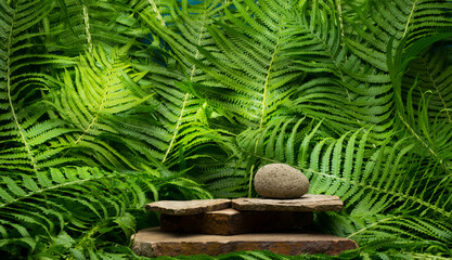 zen stones on green background for product presentation podium background.beautiful stones on fern leaves background for banner background.